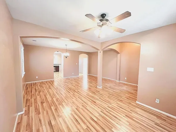 a kitchen with stainless steel appliances granite countertop a refrigerator a sink dishwasher a stove and a dining table with wooden floor