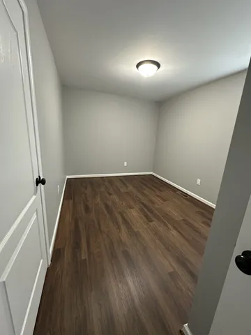 a view of a room with wooden floor