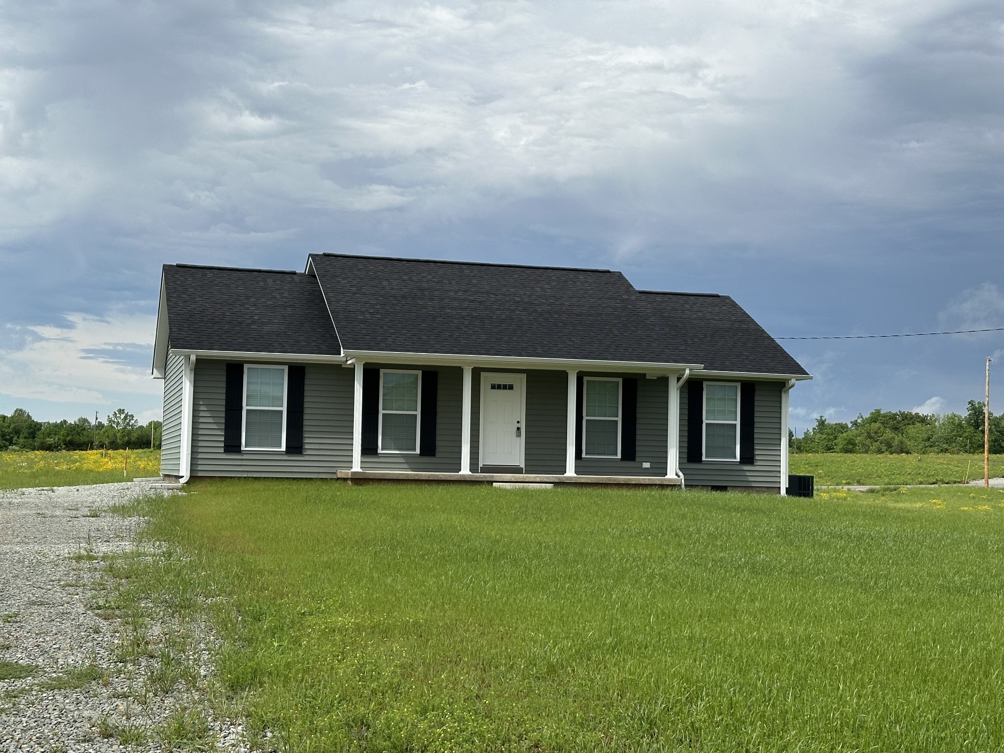 24 Henkle Lane Loretto, TN 38469 - Photo 3 of 21 a view of a white house with a big yard and potted plants and large trees