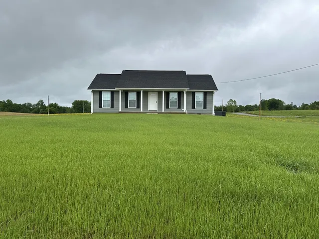 a view of a big house with a big yard and large trees