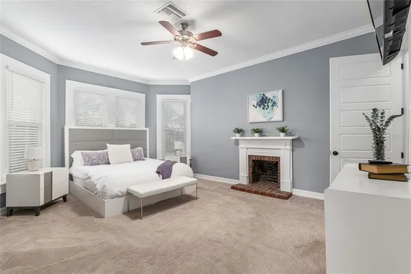 a bedroom with a bed a flat screen tv and a chandelier