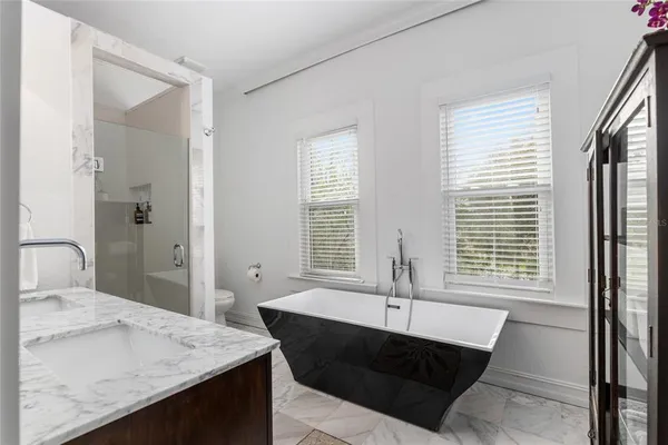 a bathroom with a granite countertop double vanity sinks and a mirror