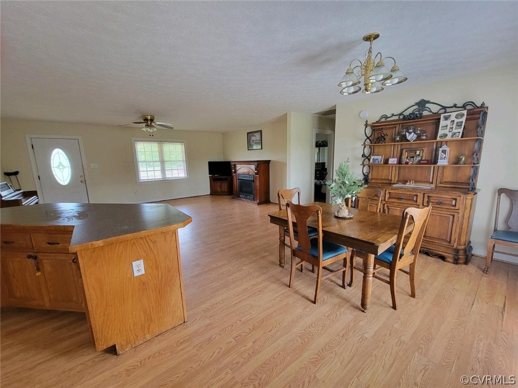 6851 Cox Road Wilsons, VA 23894 - Photo 46 of 50 a dining room with wooden floor a chandelier a wooden table and chairs