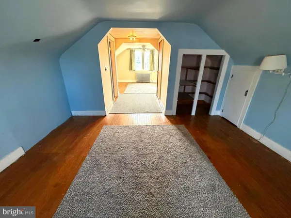 a view of a hallway with wooden floor and a living room