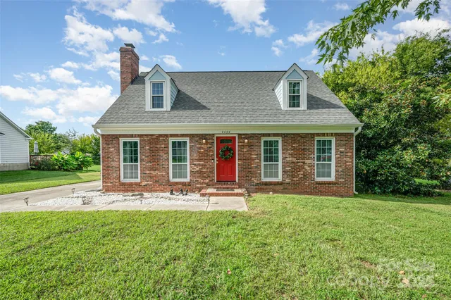 a front view of a house with a yard and outdoor seating