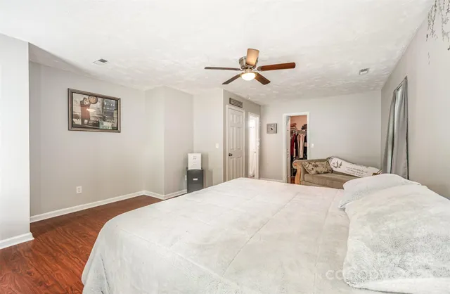 a bedroom with a large bed and a ceiling fan