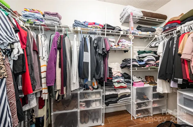 a view of walk in closet with clothes and shoes