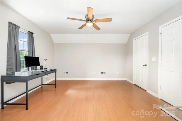 a view of a workspace with furniture and a window
