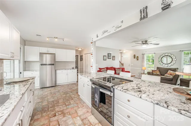 a kitchen with granite countertop a stove and a refrigerator