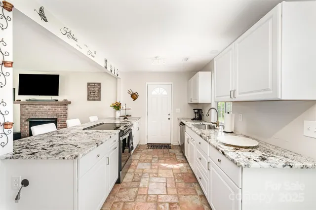 a kitchen with granite countertop a sink stove and refrigerator