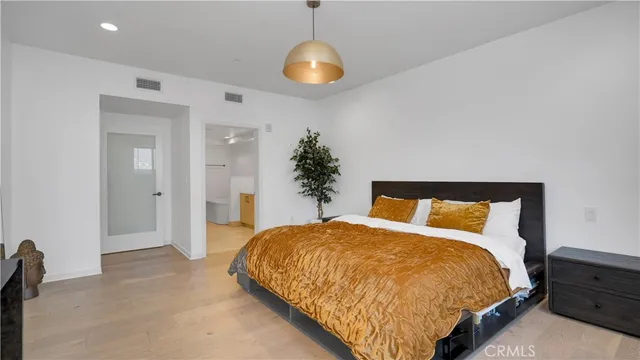 a bedroom with a bed and potted plant