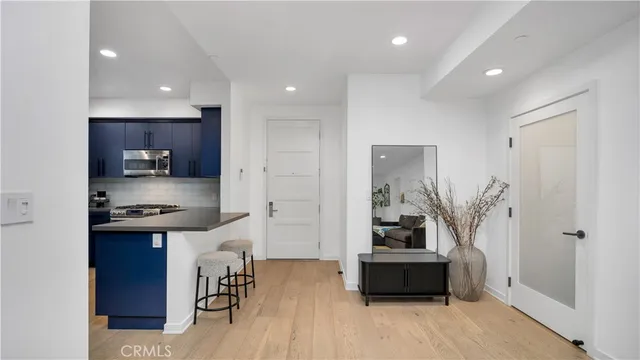 a kitchen with stainless steel appliances granite countertop a refrigerator a stove and a wooden floors