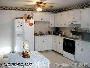 22 Tyler Street Clyde, NC 28721 - Photo 3 of 9 a kitchen with stainless steel appliances granite countertop a sink dishwasher stove and white cabinets