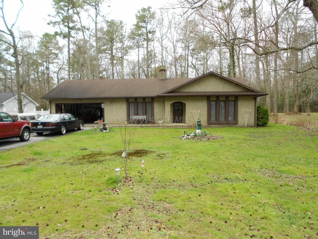 a front view of a house with a yard and trees