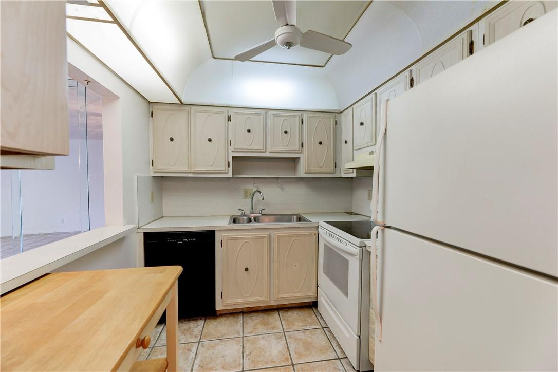 253 South Cypress Road, Unit 246 Pompano Beach, FL 33060 - Photo 21 of 33 a kitchen with white cabinets and white appliances