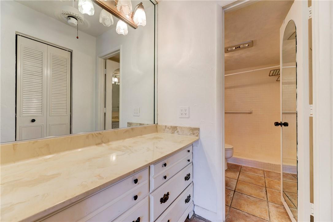 253 South Cypress Road, Unit 246 Pompano Beach, FL 33060 - Photo 24 of 33 a bathroom with a granite countertop sink a mirror and a shower