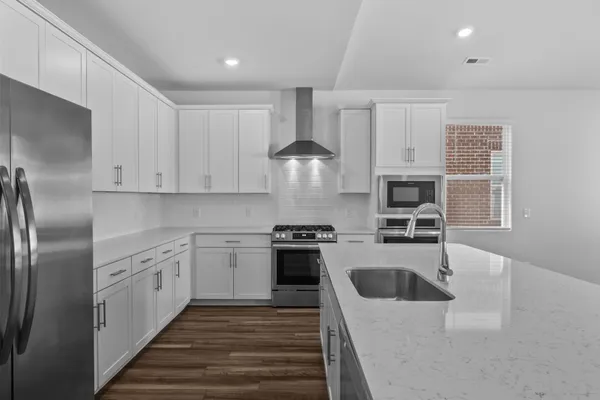 a large kitchen with kitchen island a sink stainless steel appliances and cabinets