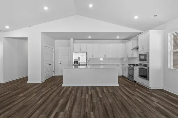a view of an empty room with wooden floor fireplace and a window