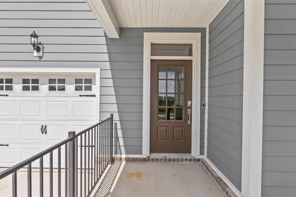 a view of a white house with large windows next to a yard