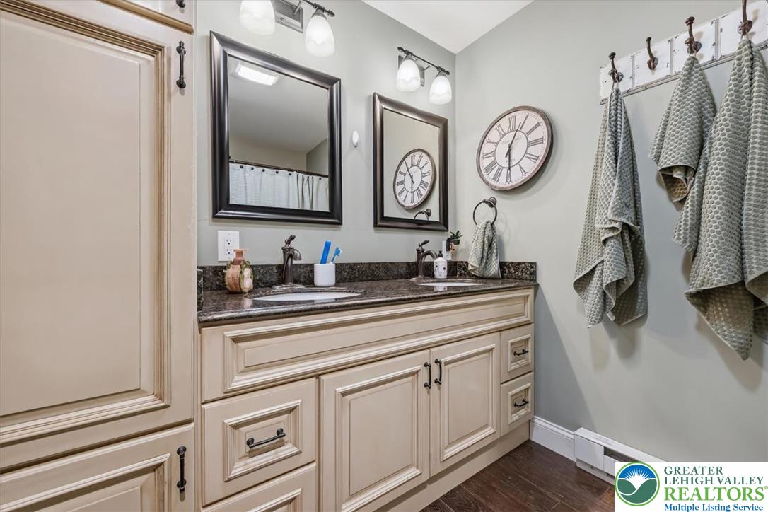 3771 State Road Coopersburg, PA 18036 - Photo 27 of 37 A well-appointed vanity offers dual sinks, granite countertops, and rich hardwood flooring.