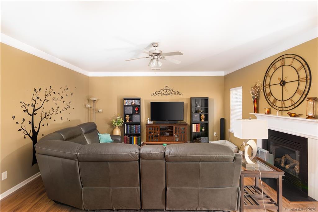 1703 Newland Road, Unit 124 Denver, NC 28037 - Photo 4 of 11 a living room with furniture a fireplace and a flat screen tv