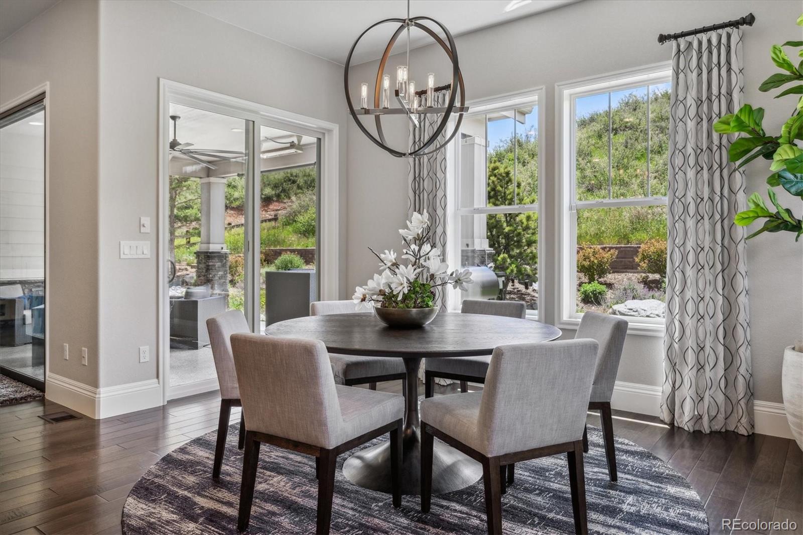 4837 Hogback Ridge Road Morrison, CO 80465 - Photo 16 of 40 a dining room with furniture a chandelier and wooden floor