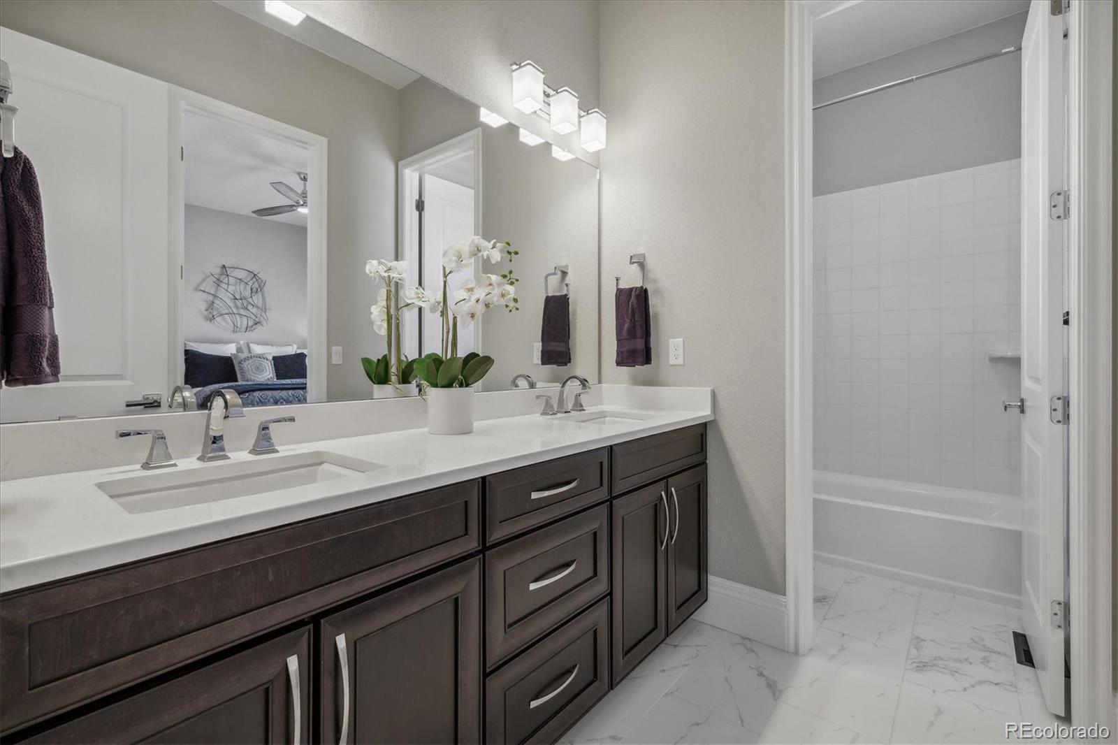 4837 Hogback Ridge Road Morrison, CO 80465 - Photo 30 of 40 a bathroom with a double vanity sink a mirror and a bathtub