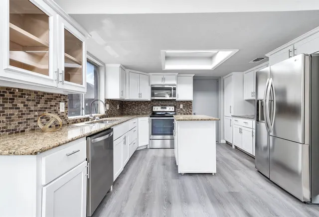 a kitchen with granite countertop a sink and cabinets