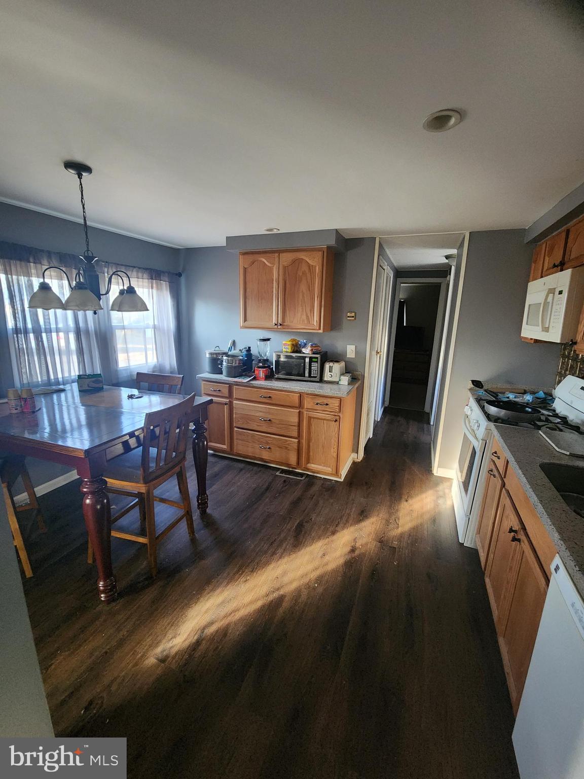 302 Arizona Avenue Williamstown, NJ 08094 - Photo 11 of 11 a kitchen with granite countertop wooden floor a dining table and chairs