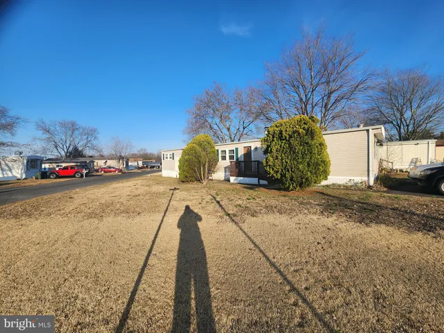 an empty room with wooden floor fireplace and windows