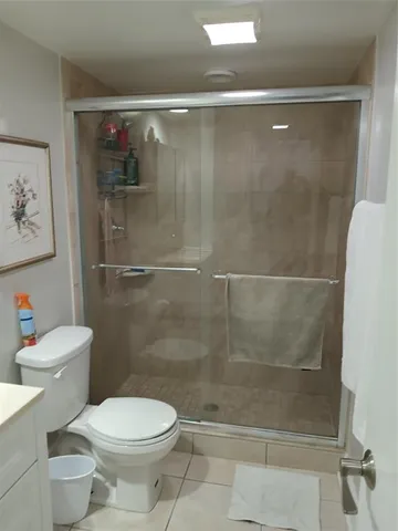 a white toilet sitting next to a shower