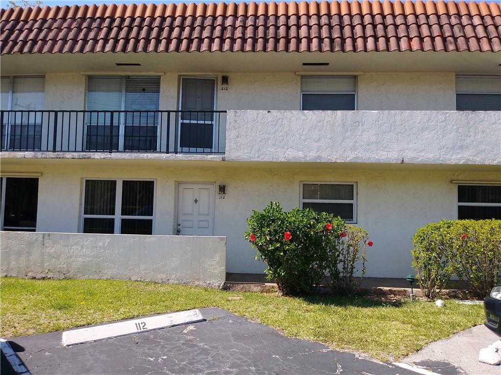 55 Southeast 14th Street, Unit 1120 Boca Raton, FL 33432 - Photo 2 of 24 a front view of a house with a yard