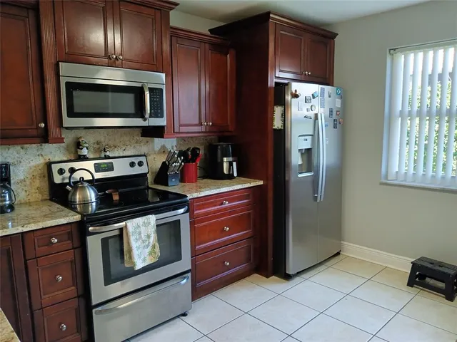 a kitchen with stainless steel appliances granite countertop wooden cabinets a stove top oven a sink and dishwasher