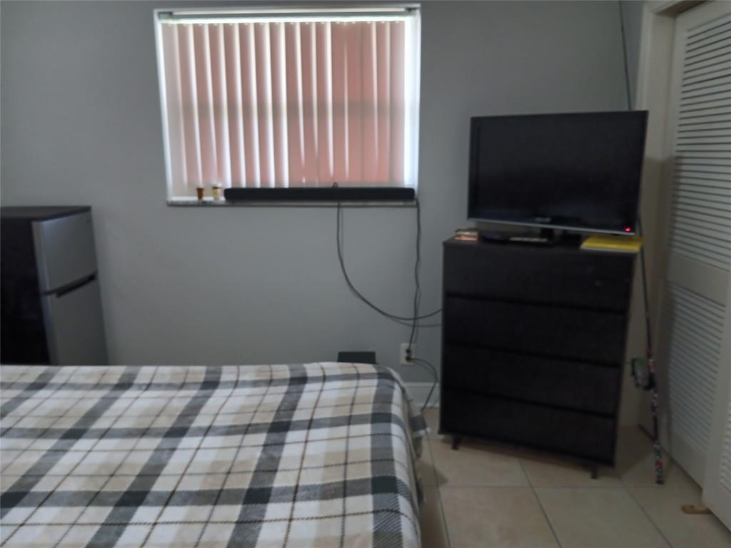 55 Southeast 14th Street, Unit 1120 Boca Raton, FL 33432 - Photo 9 of 24 a bedroom with a bed and a flat tv screen on the dresser