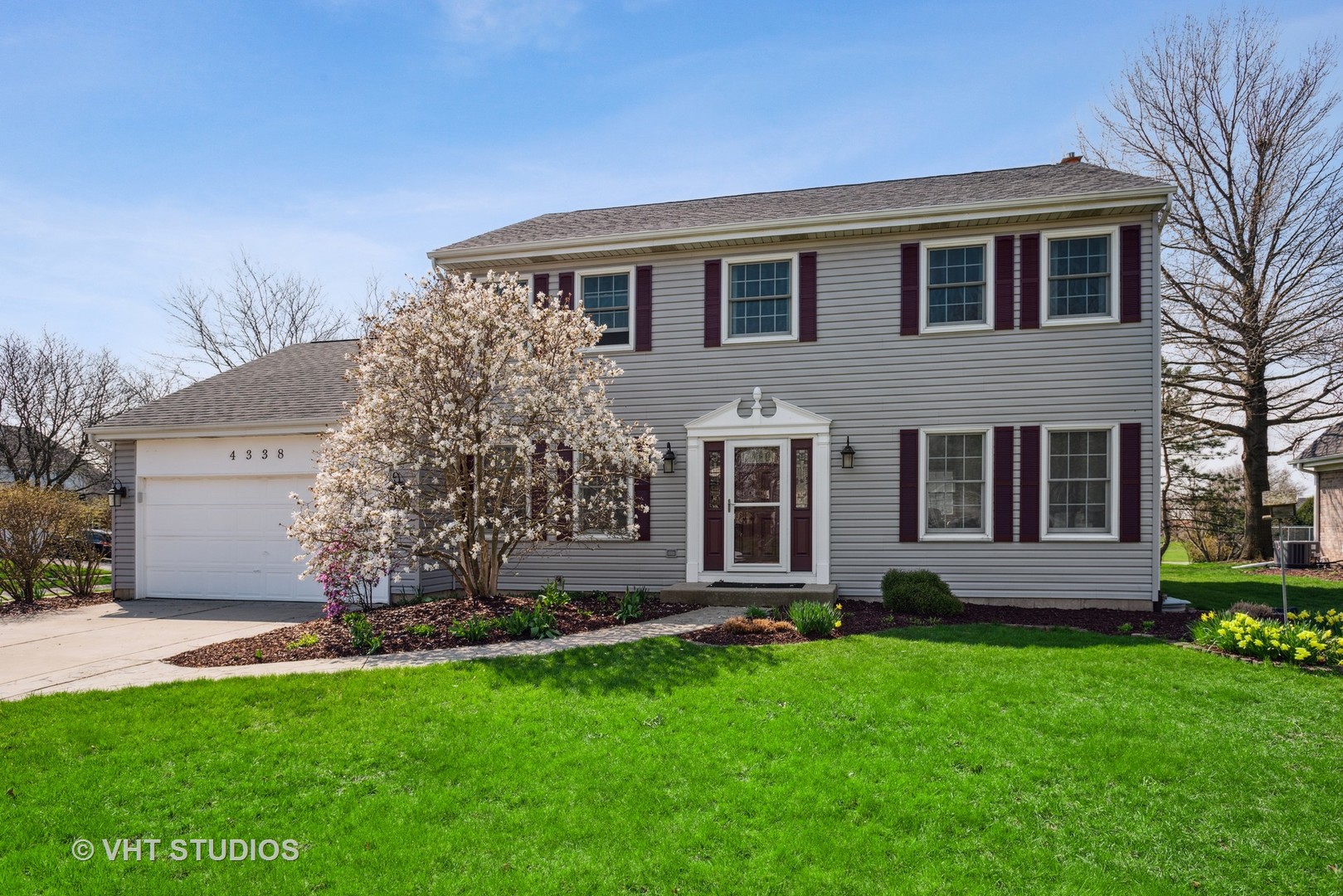a front view of a house with a garden and yard