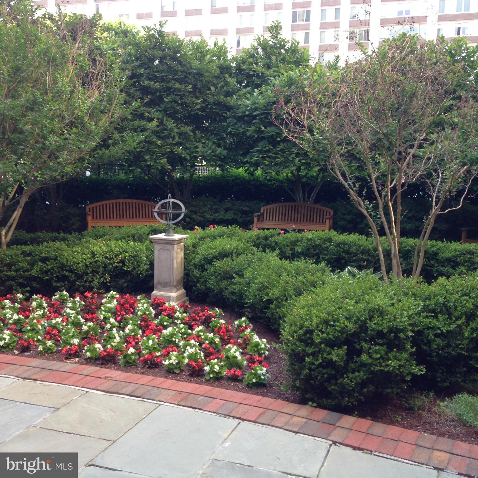 11710 Old Georgetown Road, Unit 1213 North Bethesda, MD 20852 - Photo 1 of 15 a garden with flowers and a bench