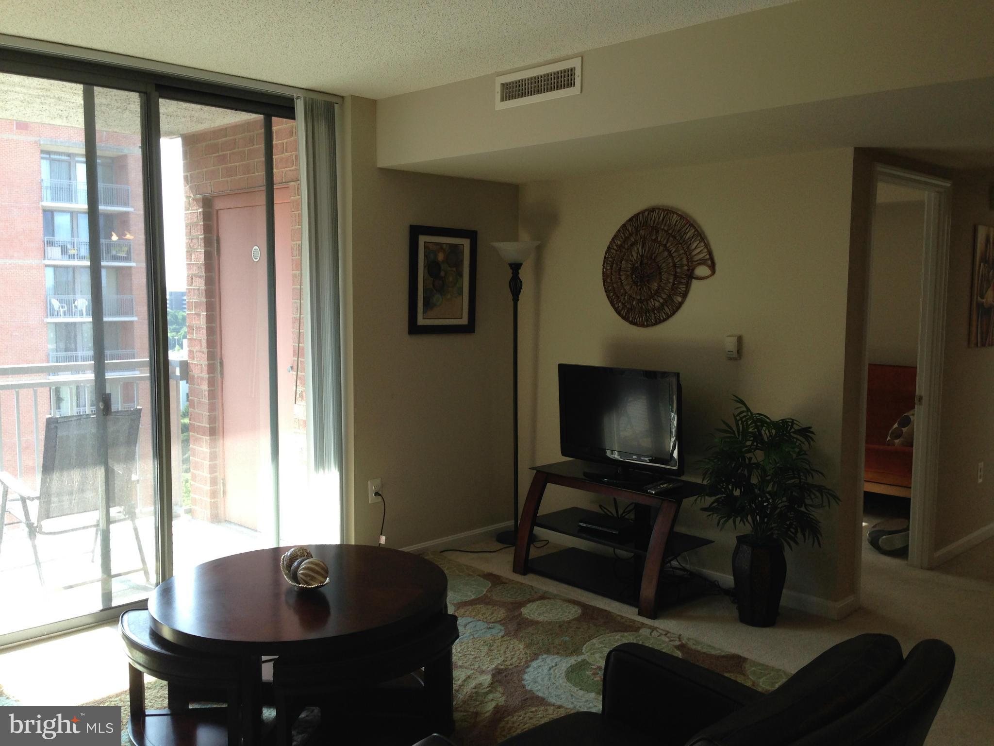 11710 Old Georgetown Road, Unit 1213 North Bethesda, MD 20852 - Photo 7 of 15 a living room with furniture and a flat screen tv
