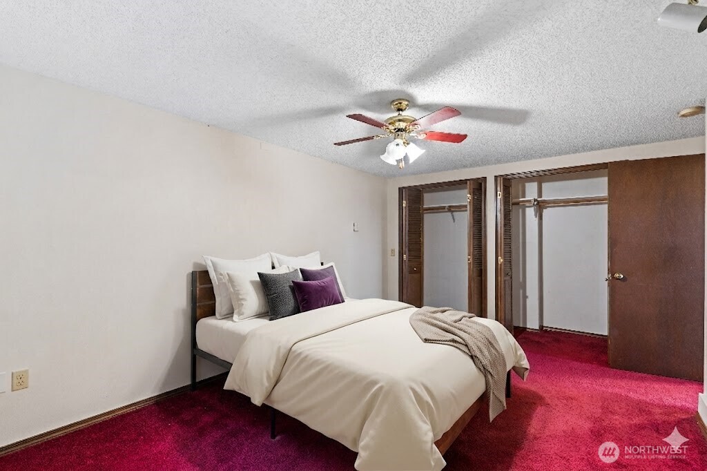 2113 East Grand Avenue Everett, WA 98201 - Photo 5 of 22 a spacious bedroom with a bed and a chandelier