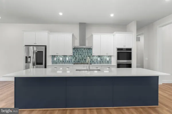a kitchen with kitchen island sink and refrigerator