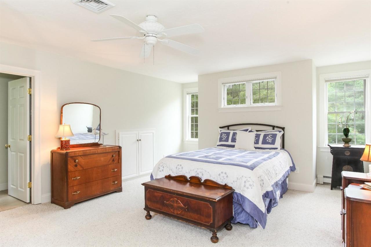 693 Great Neck Road South Mashpee, MA 02649 - Photo 19 of 23 a bedroom with a bed and a chandelier