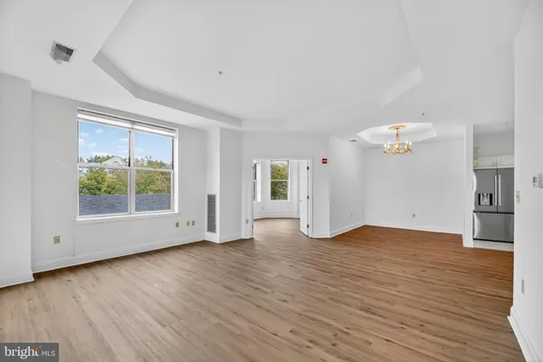 an empty room with wooden floor and window