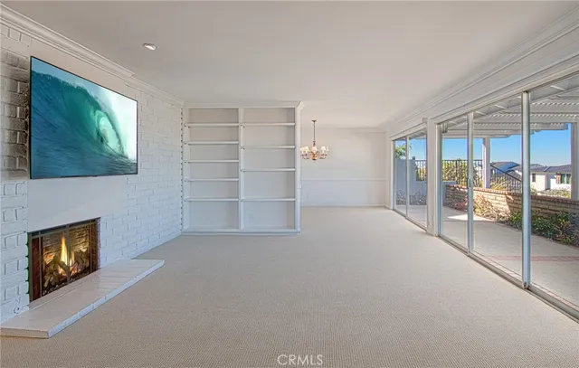 a view of an empty room with a fireplace and a window