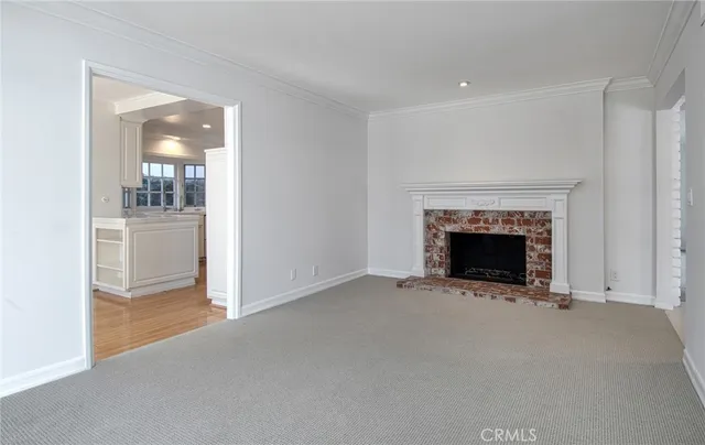 an empty room with a fireplace and chandelier