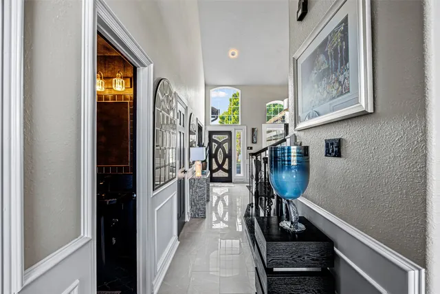 a hallway with painting on the wall and a window