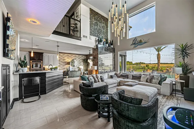 a living room with furniture a chandelier and kitchen view