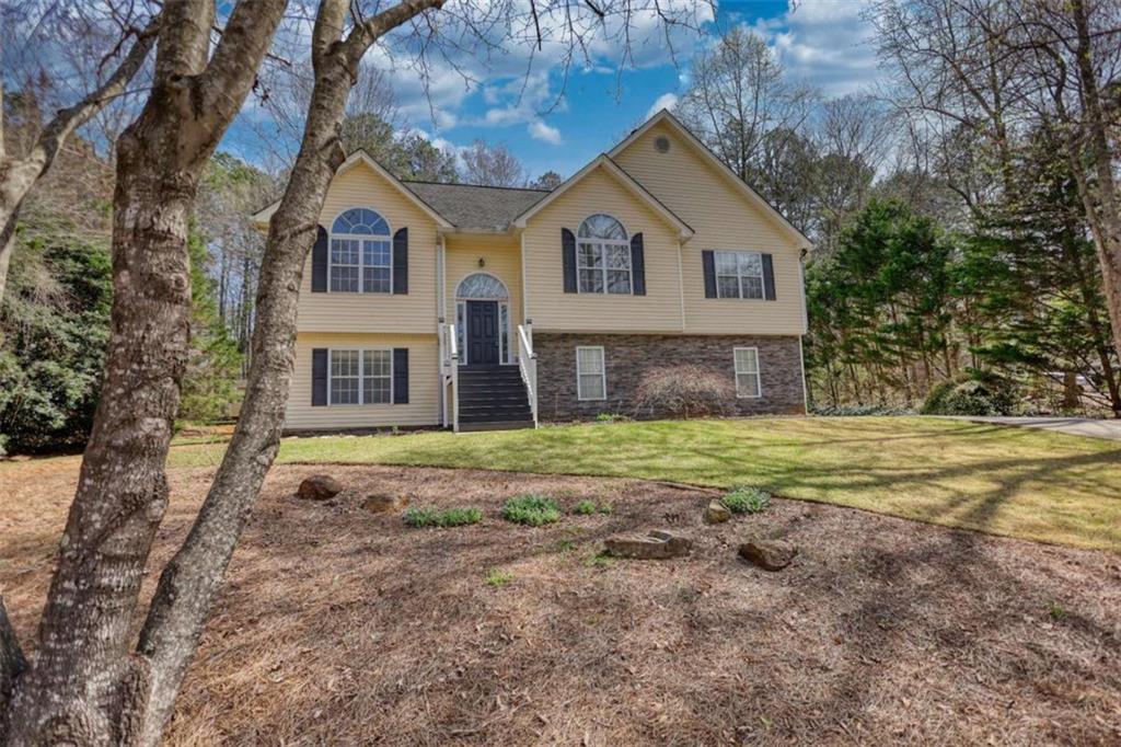 1006 English Oak Lane Winder, GA 30680 - Photo 1 of 83 a view of a yard in front of a house with a large tree