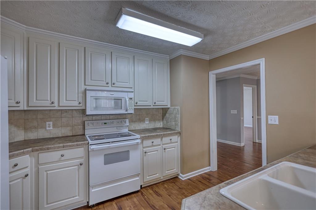 1006 English Oak Lane Winder, GA 30680 - Photo 22 of 83 a kitchen with white cabinets and white appliances