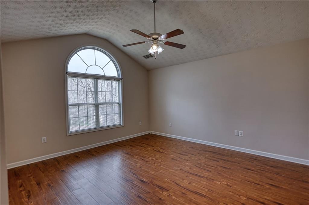 1006 English Oak Lane Winder, GA 30680 - Photo 24 of 83 an empty room with wooden floor chandelier fan and windows