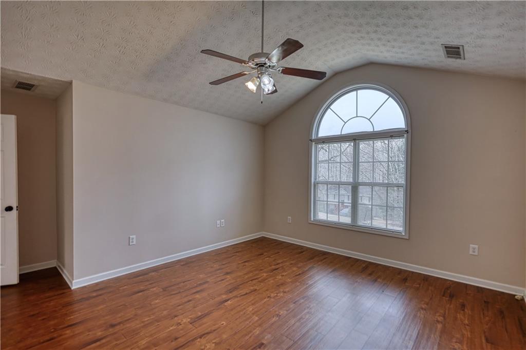 1006 English Oak Lane Winder, GA 30680 - Photo 25 of 83 an empty room with wooden floor chandelier fan and windows