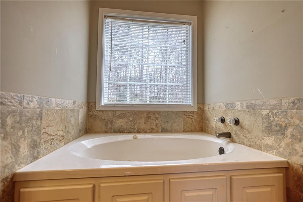1006 English Oak Lane Winder, GA 30680 - Photo 28 of 83 a bathroom with a bathtub and a window